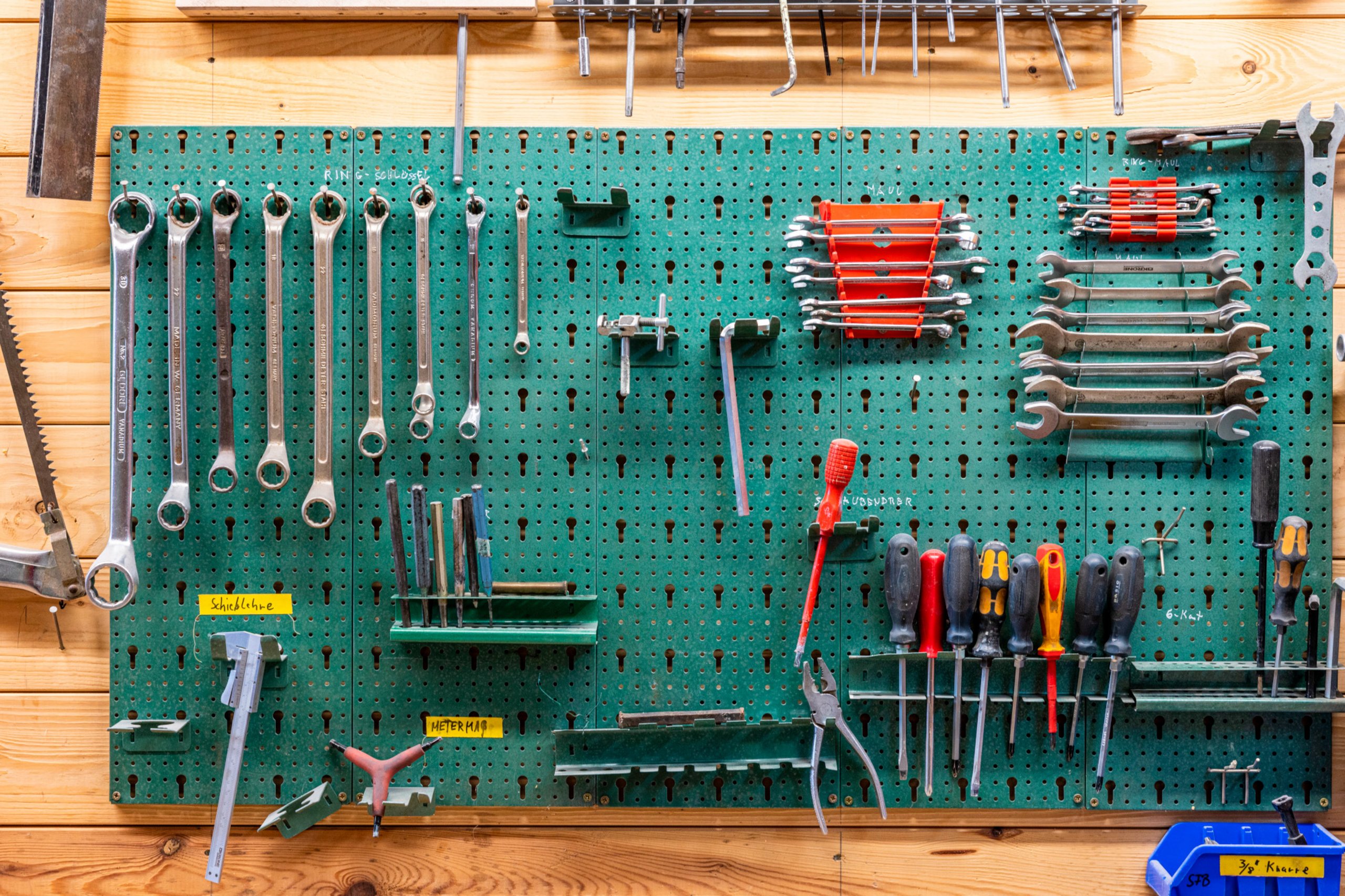 Werkzeugkasten: Werkzeug hängt an einer grünen Wand.