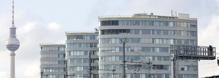 Drei Hochhäuser und der Fernsehturm vor dem Hintergrund des Himmels in Berlin.