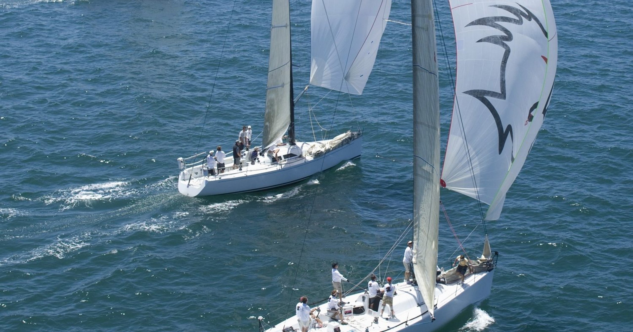 Zwei Segelboote mit Crew auf dem Wasser