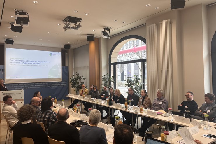 Das Bild zeigt die Teilnehmenden des Workshops "Intensivierung der Zusammenarbeit zwischen kommunalen Akteuren", die an einem U-förmigen Tisch sitzen. .